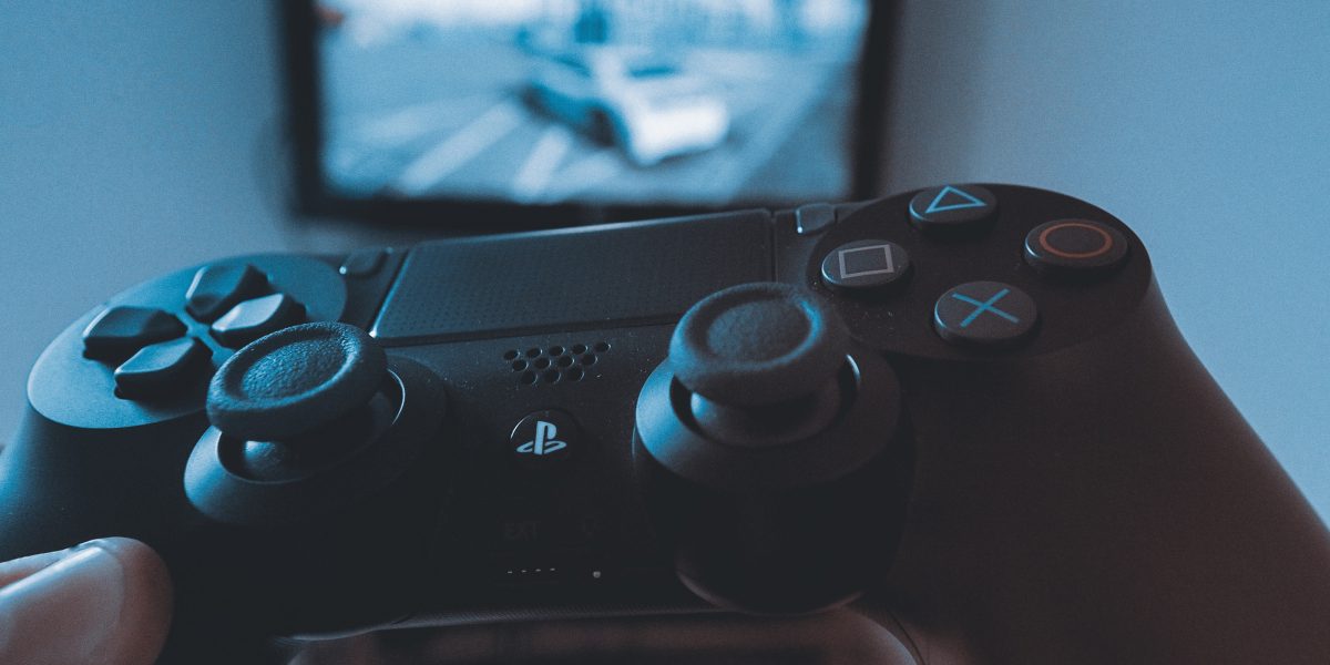Hand holding Playstation controller playing story mode