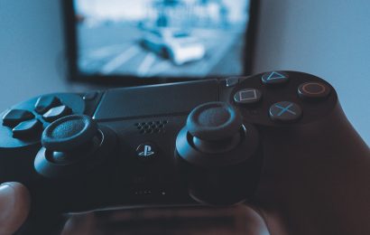 Hand holding Playstation controller playing story mode