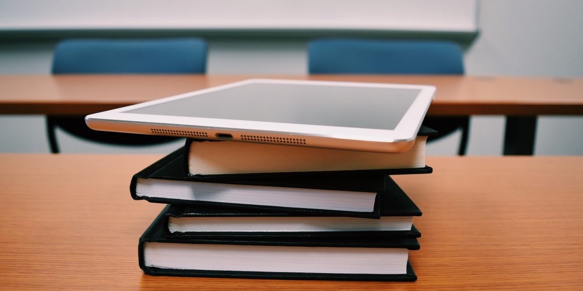 Tablet on top of books on a desk