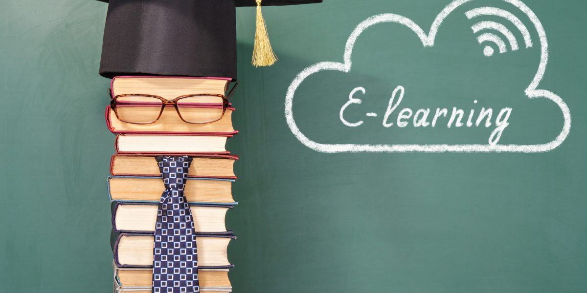 E-learning written on the back of the blackboard and beside a stack of books